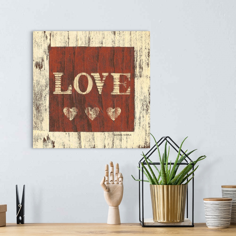 A bohemian room featuring Inspirational artwork of the word ""LOVE"" with three hearts underneath in a red square painted o...