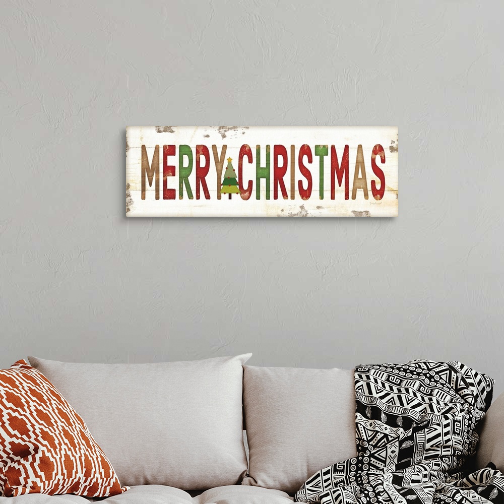 A bohemian room featuring Christmas themed typography artwork in festive seasonal colors against a distressed background.