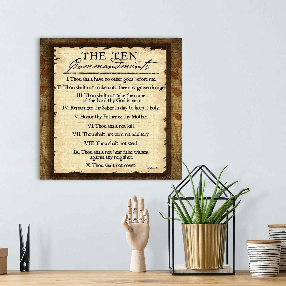 A bohemian room featuring This large square piece lists the ten commandments with a decorative border around them.