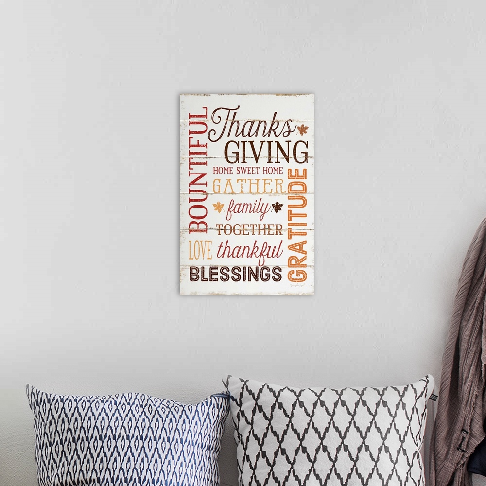 A bohemian room featuring Thanksgiving themed typography artwork in festive fall colors against a rustic wooden background.