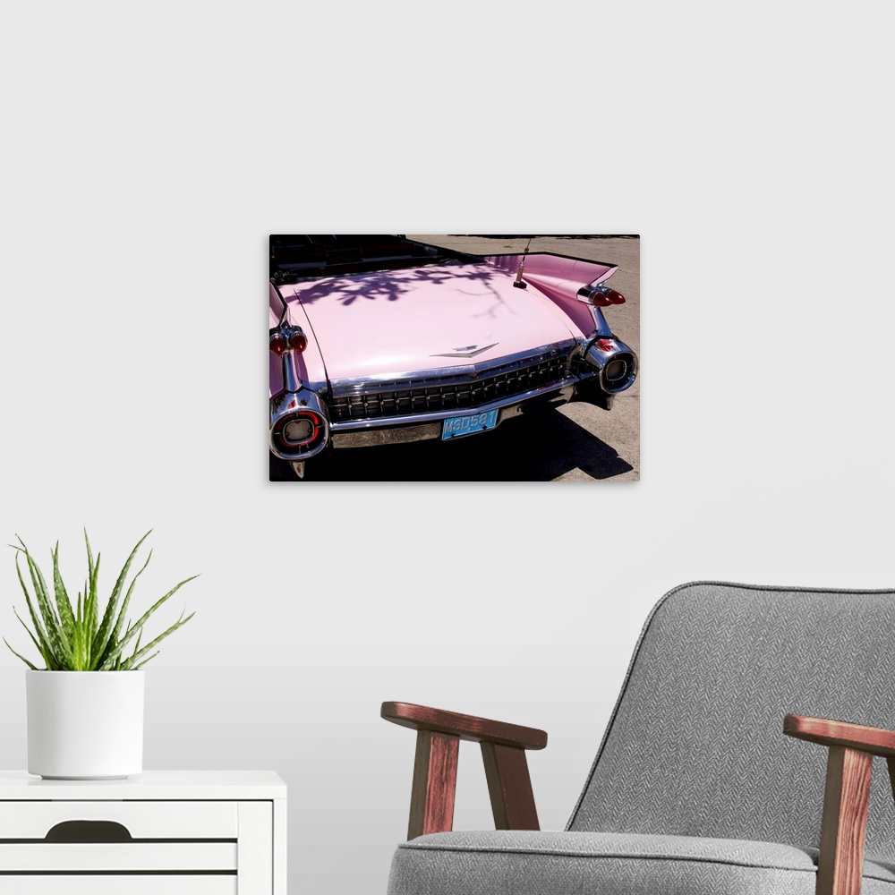 A modern room featuring Classic 1959 pink Cadillac convertible on road in beautiful Varadero Beach in Valadero Cuba