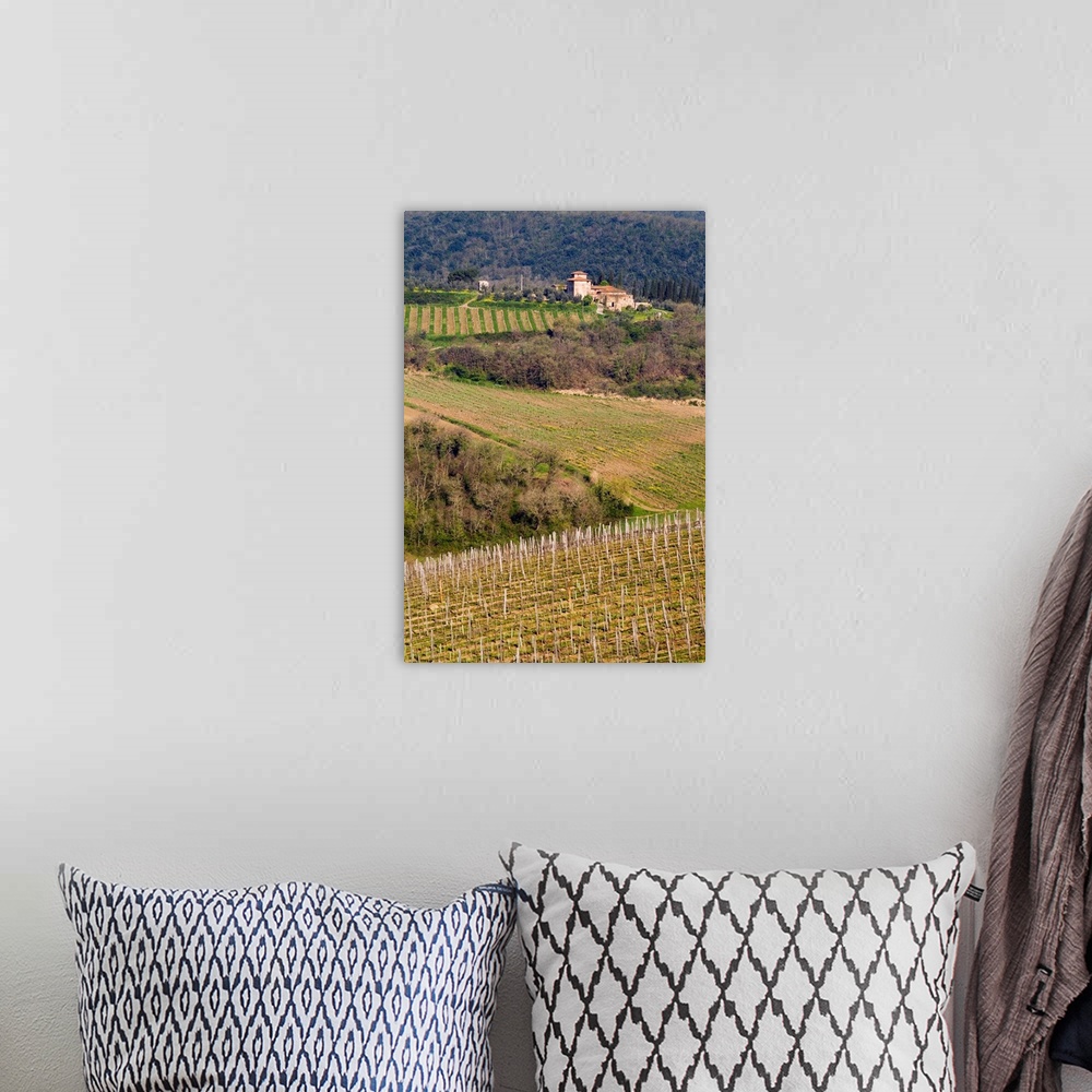 A bohemian room featuring A grand stone winery stands above rolling vineyards, Chianti, Tuscany, Italy.