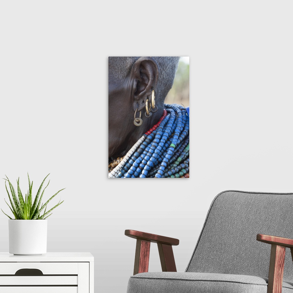 A modern room featuring Africa, Ethiopia, Southern Omo Valley, Nyangaton Tribe.  An elderly Nyangton woman with four ear ...