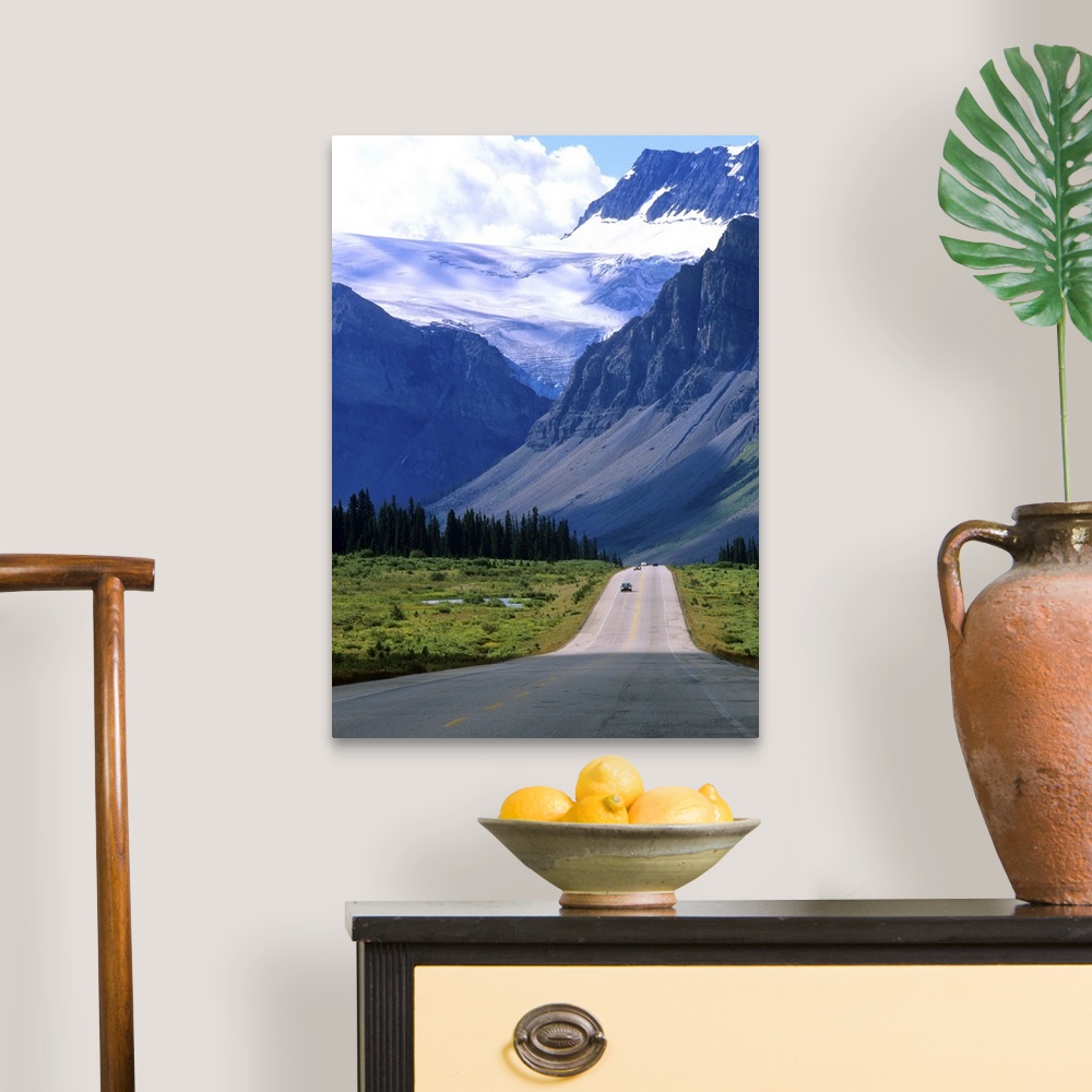A traditional room featuring A road into the mountains of Banff National Park, where fierce clouds and snowcapped peaks loom i...