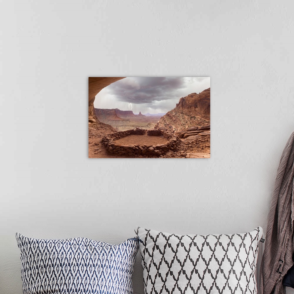A bohemian room featuring USA, Utah, Canyonlands National Park. View of Anasazi ruin with thundercloud and lightning in bac...