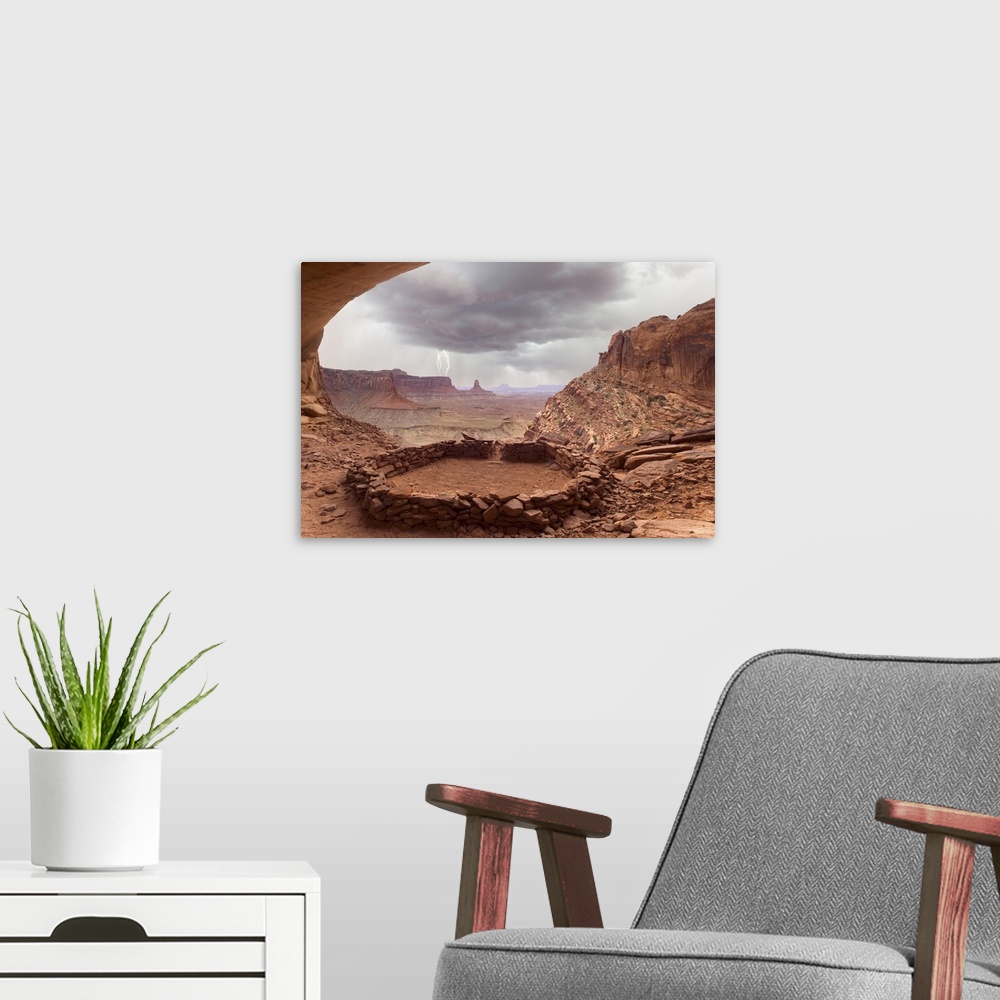 A modern room featuring USA, Utah, Canyonlands National Park. View of Anasazi ruin with thundercloud and lightning in bac...