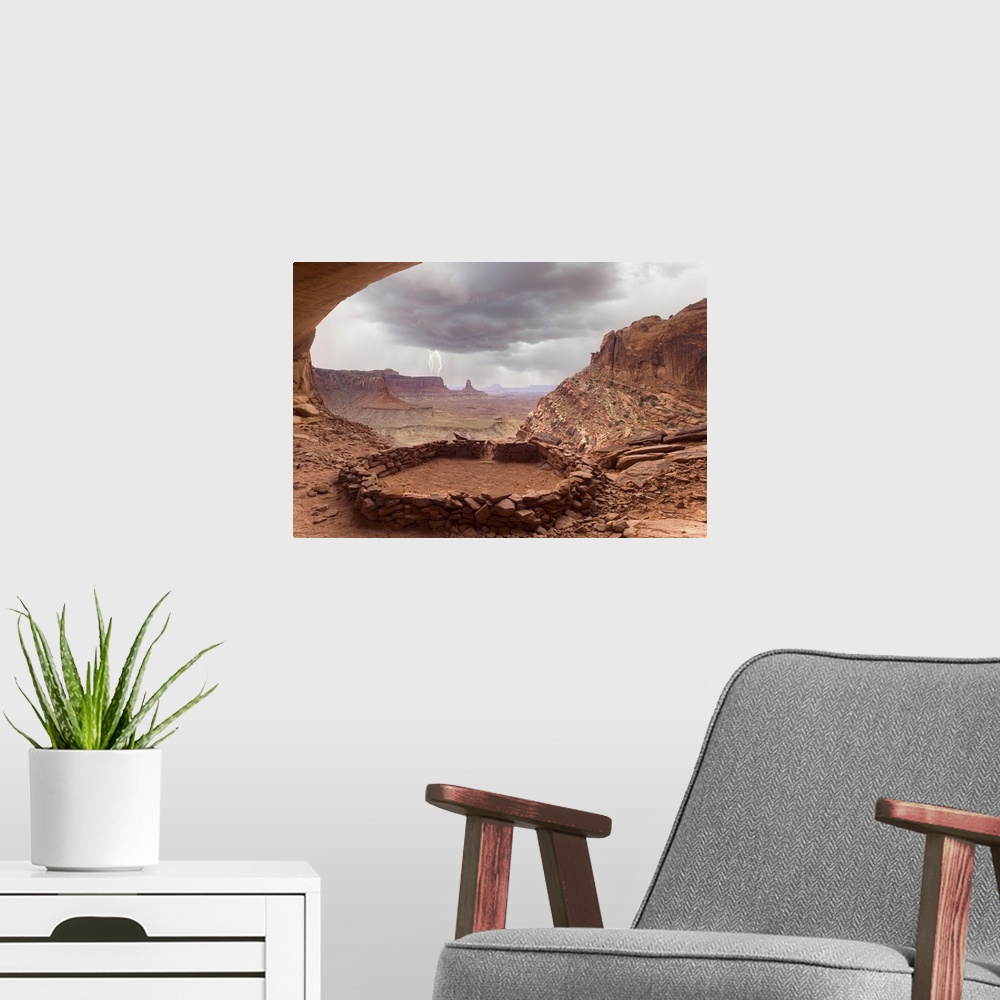 A modern room featuring USA, Utah, Canyonlands National Park. View of Anasazi ruin with thundercloud and lightning in bac...