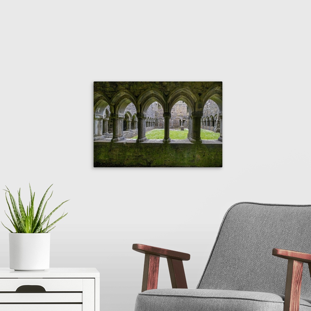 A modern room featuring Ancient cloisters surround this patch of grass at Moyne Abbey, County Mayo, Ireland.