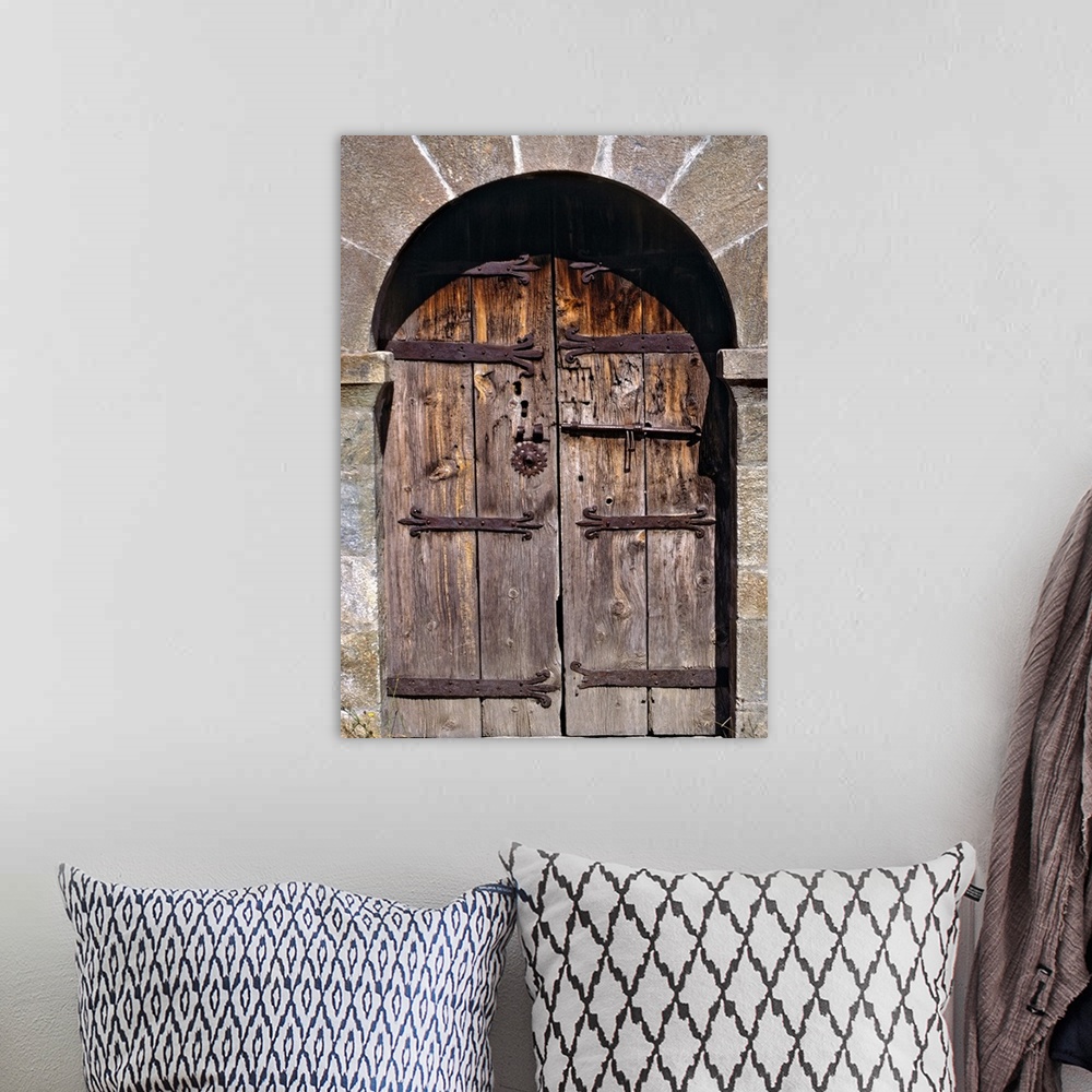 A bohemian room featuring Europe, Andorra. An ancient old wooden door contrasts against a stone building in Andorra.