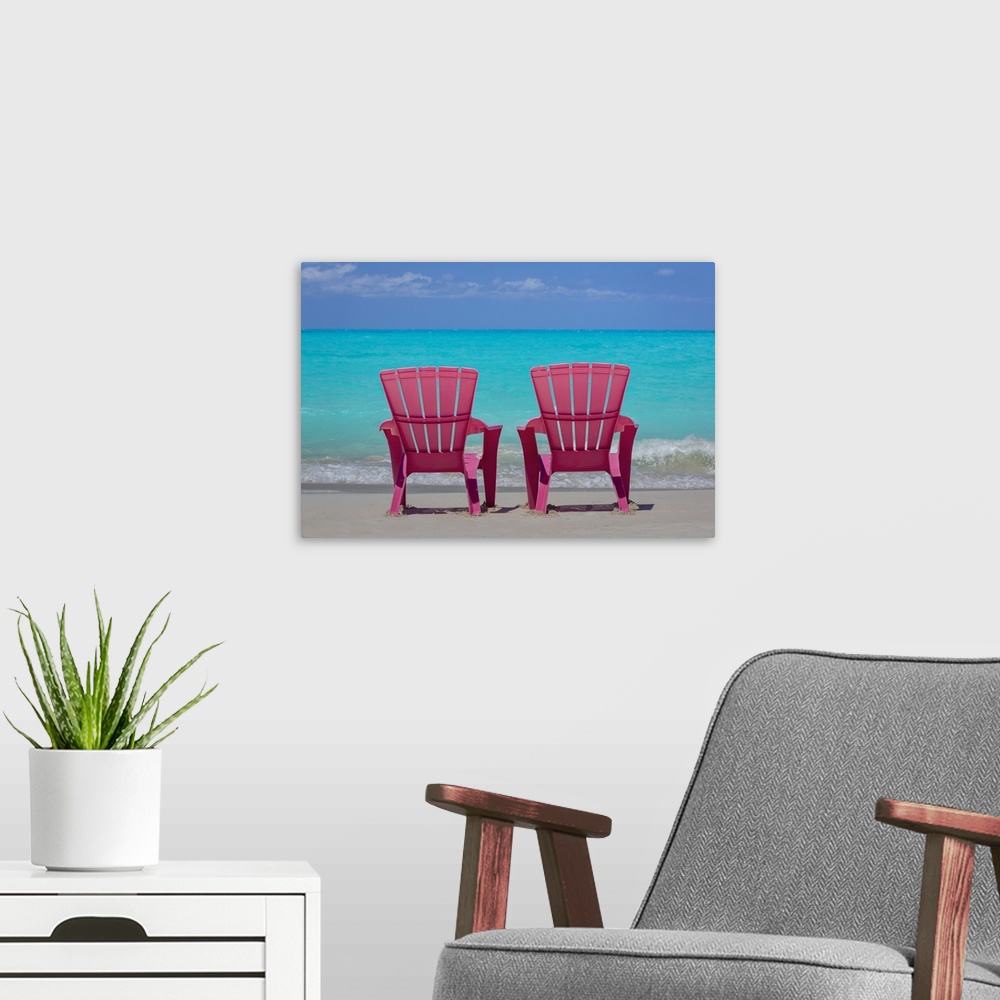 A modern room featuring Bahamas, Little Exuma Island. Pink chairs on beach.