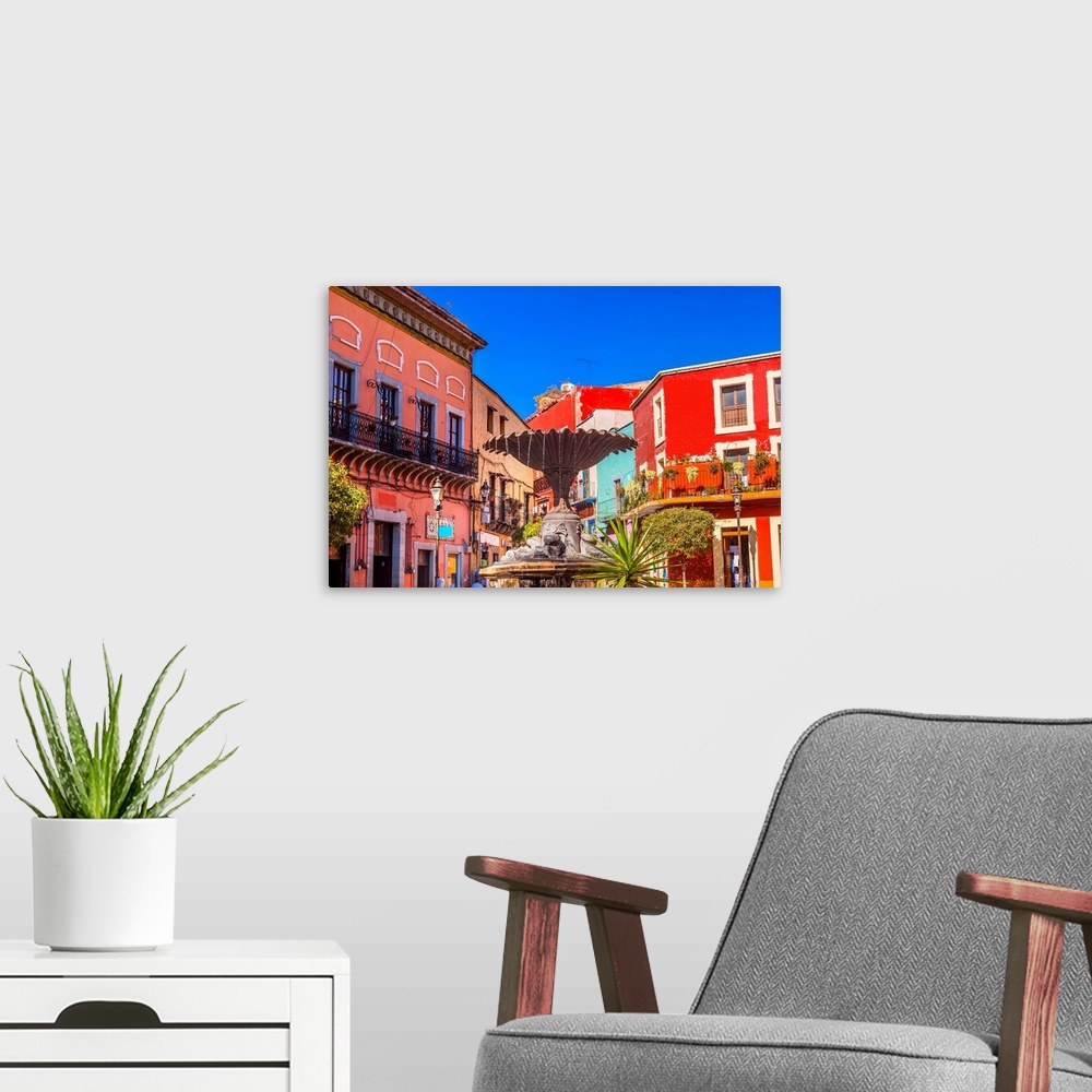 A modern room featuring Plaza Del Baratillo, Baratillo Square, Fountain, colorful buildings, Guanajuato, Mexico .