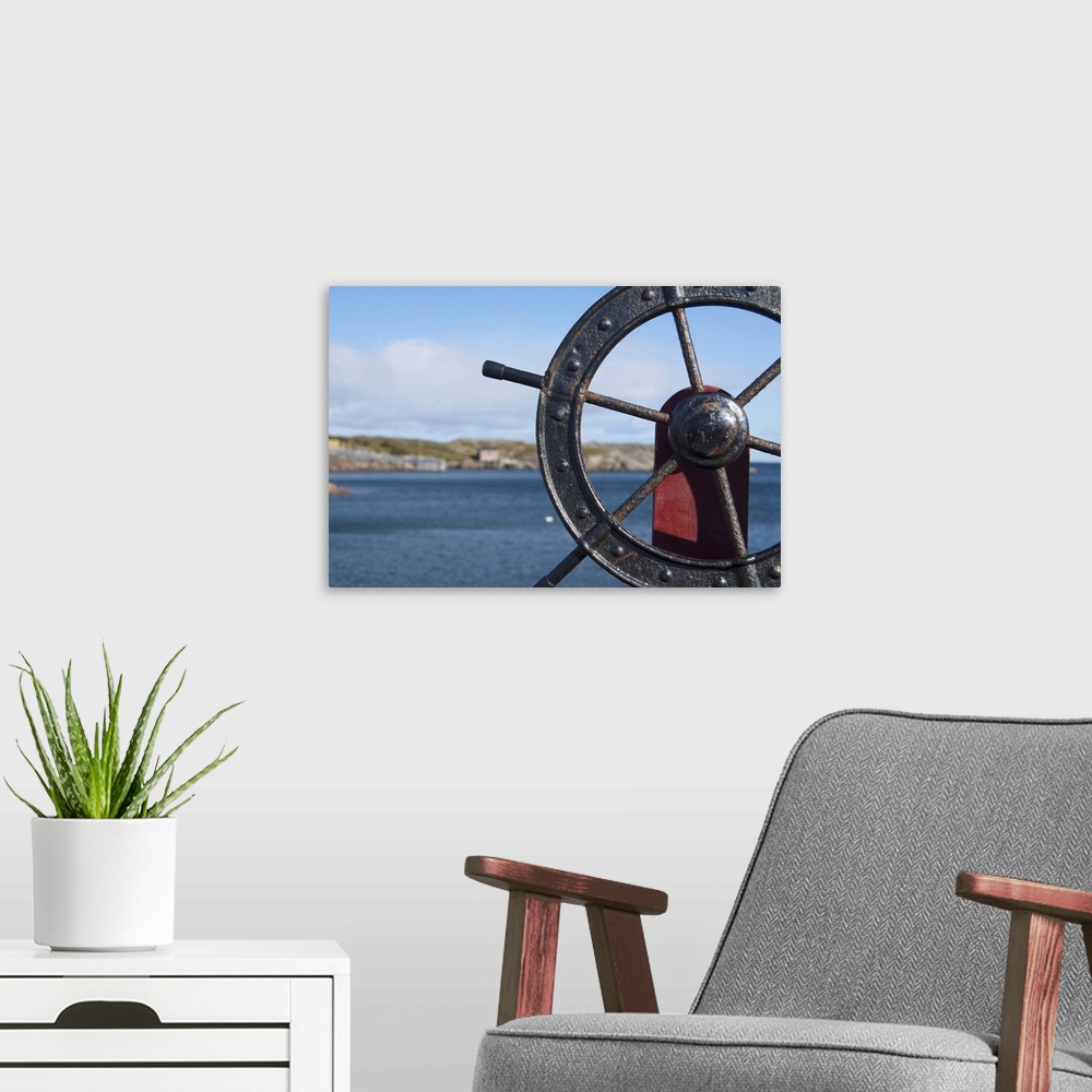 A modern room featuring Canada, Newfoundland and Labrador, Twillingate. Fisherman's Point, boat wheel in front of scenic ...