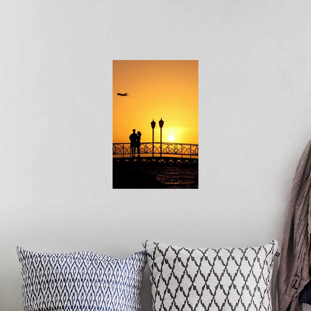 A bohemian room featuring Caribbean, Aruba, Oranjestad. Couple enjoying sunset with plane overhead