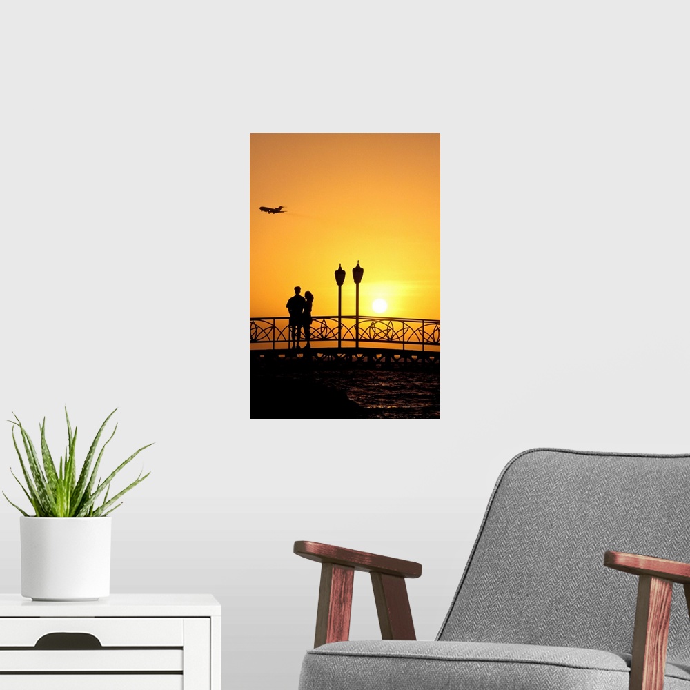 A modern room featuring Caribbean, Aruba, Oranjestad. Couple enjoying sunset with plane overhead