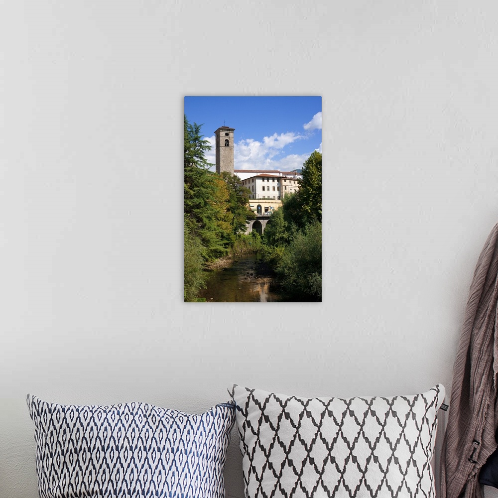 A bohemian room featuring Castelnuovo di Garfagnana, Tuscany, Italy - Old world buildings as seen behind a small waterway a...