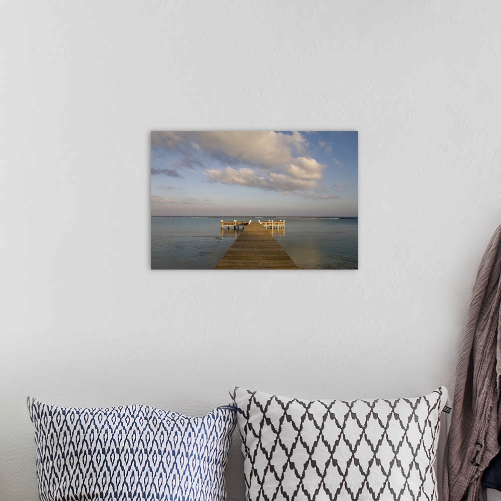 A bohemian room featuring Cayman Islands, Little Cayman Island, Setting sun lights wooden boat pier in Caribbean Sea