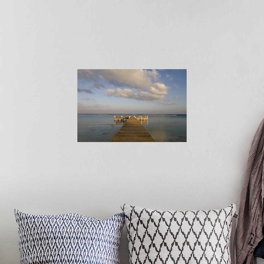 A bohemian room featuring Cayman Islands, Little Cayman Island, Setting sun lights wooden boat pier in Caribbean Sea