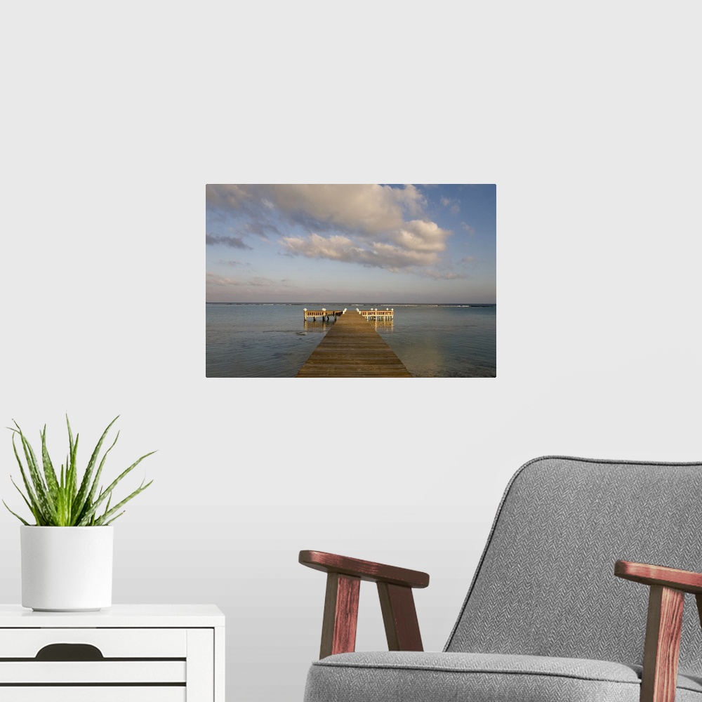 A modern room featuring Cayman Islands, Little Cayman Island, Setting sun lights wooden boat pier in Caribbean Sea