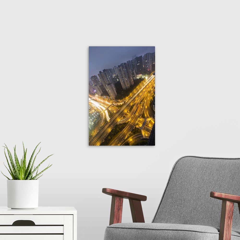 A modern room featuring China, Chongqing, Traffic on expressways surrounded by apartment towers at dusk.