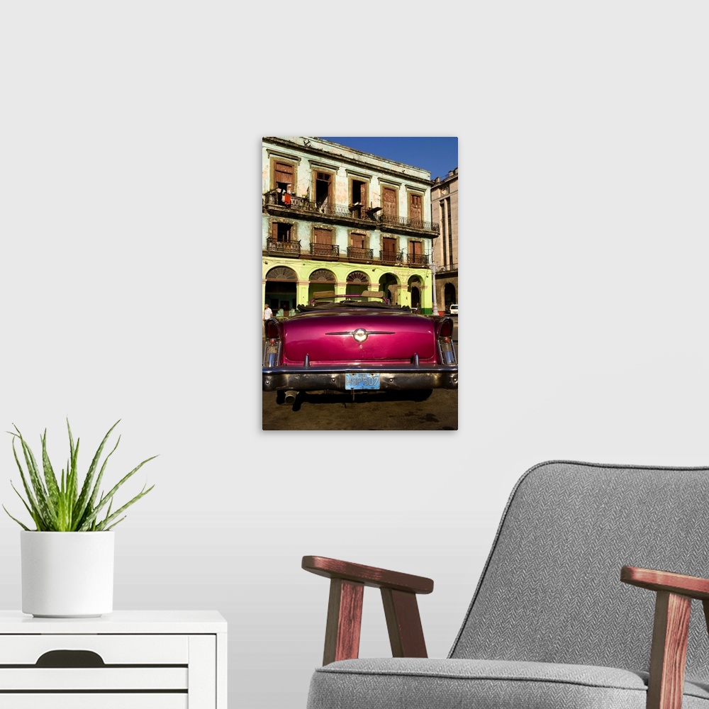 A modern room featuring Classic 50s Buick colorful convertible auto in Havana Cuba Habana in front of old worn and colorf...