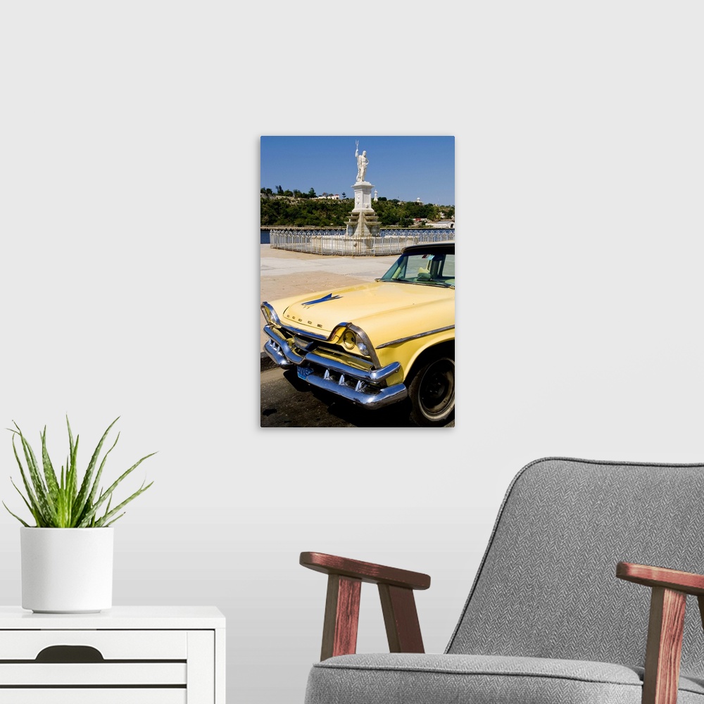 A modern room featuring Classic Dodge 50s auto in front of river and statues with Christ statue on hill in background in ...