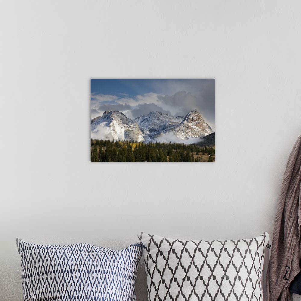 A bohemian room featuring USA, Colorado, San Juan Mountains, Uncompahgre National Forest. Clouds swirl around the snow-cove...