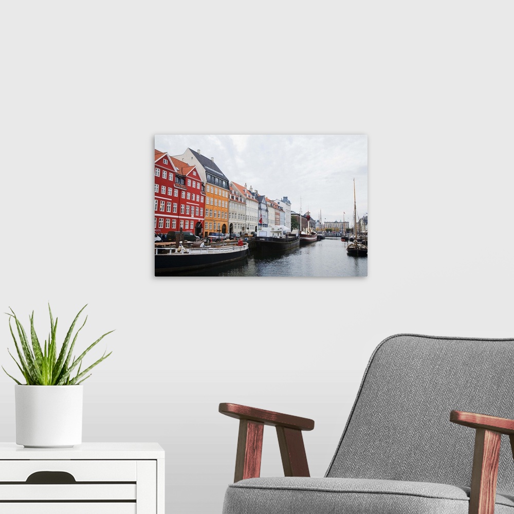 A modern room featuring Copenhagen, Denmark - On old world, waterfront city. Boats are viewable on the water. Horizontal ...