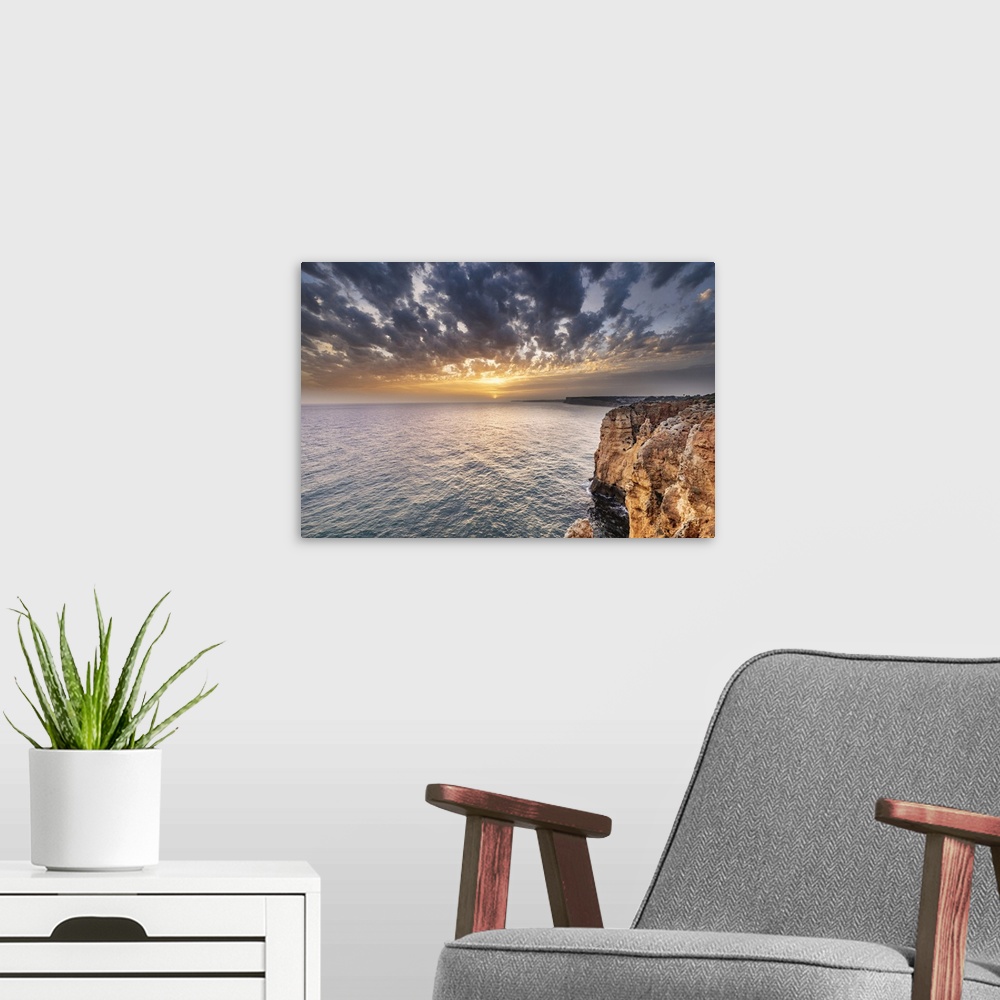 A modern room featuring Dramatic sunset clouds over Cliffs along the coast at Ponta da Piedade in Lagos, Portugal.