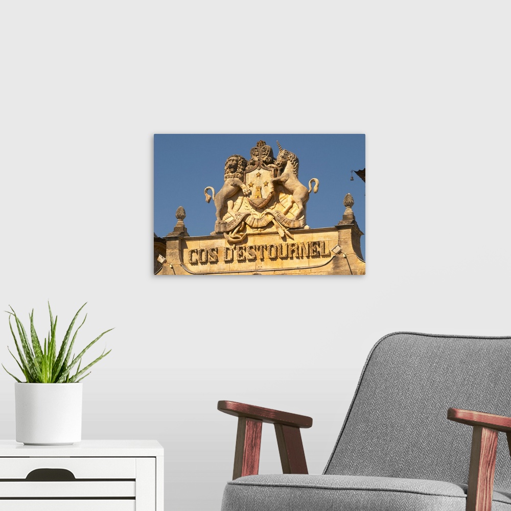 A modern room featuring The entrance portico to the elaborately decorated winery with text and coat of arms showing a tow...