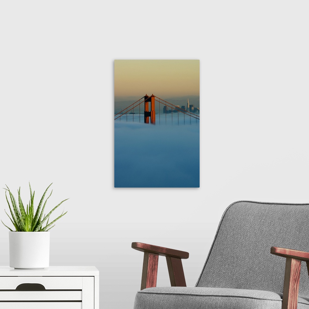 A modern room featuring Fog rolls through the San Francisco bay covering the Golden Gate Bridge and city. Pictured is the...