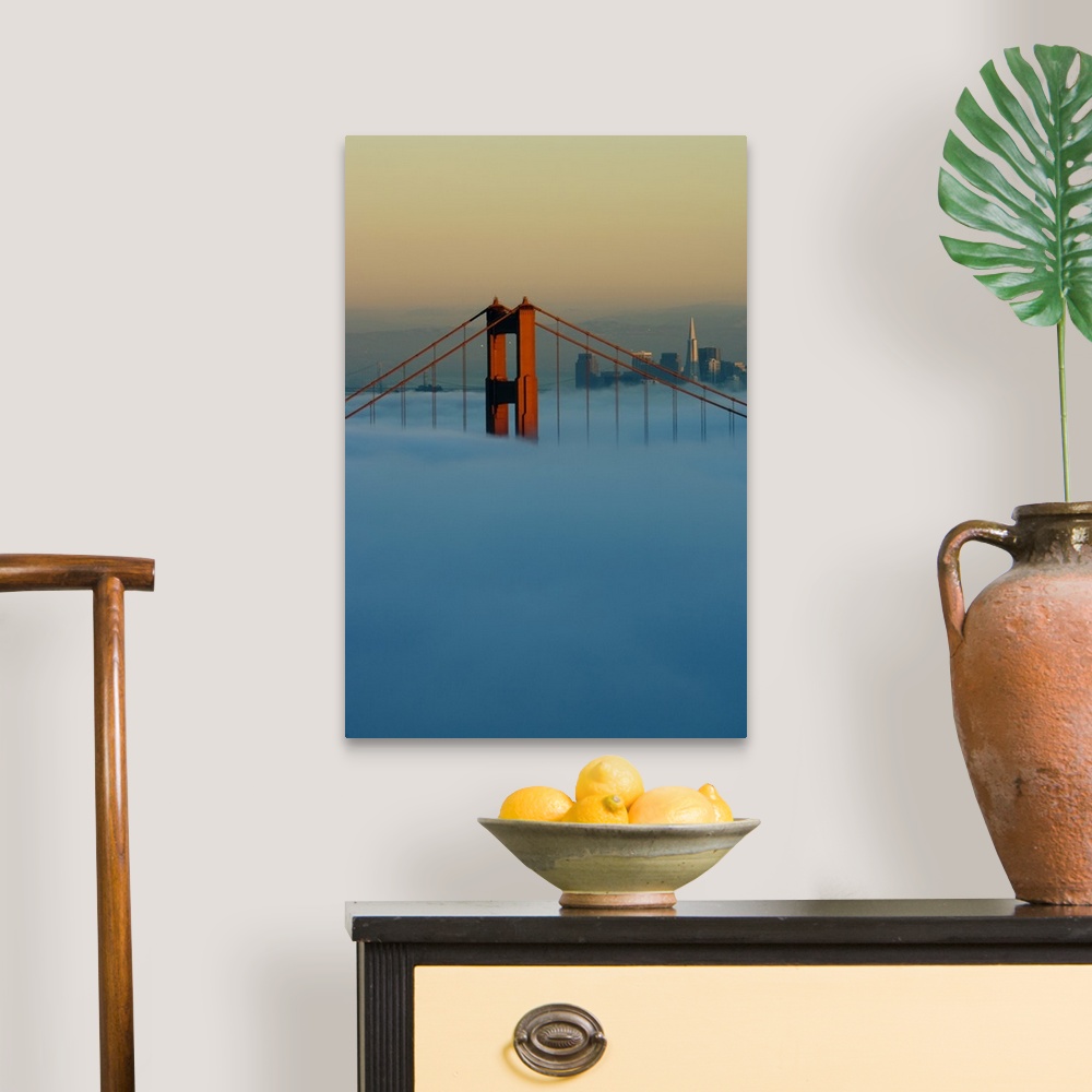 A traditional room featuring Fog rolls through the San Francisco bay covering the Golden Gate Bridge and city. Pictured is the...