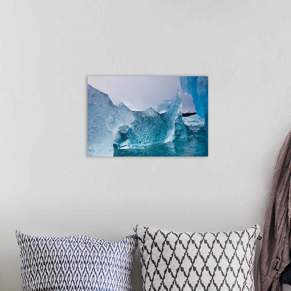 A bohemian room featuring Norway, Svalbard, Spitsbergen Island, Deep blue icebergs floating near face of Sveabreen Glacier ...