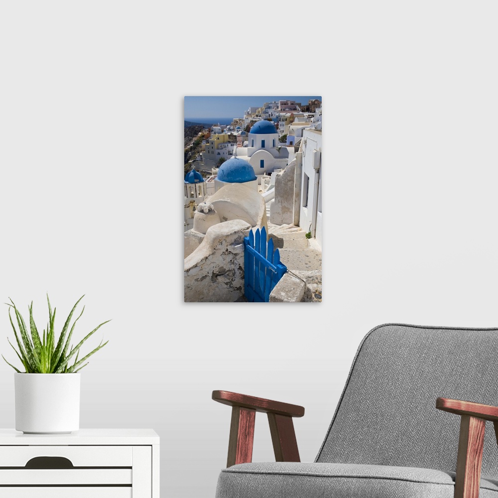 A modern room featuring Greece and Greek Island of Santorini town of Oia with Blue Domed Churches with white and colorful...
