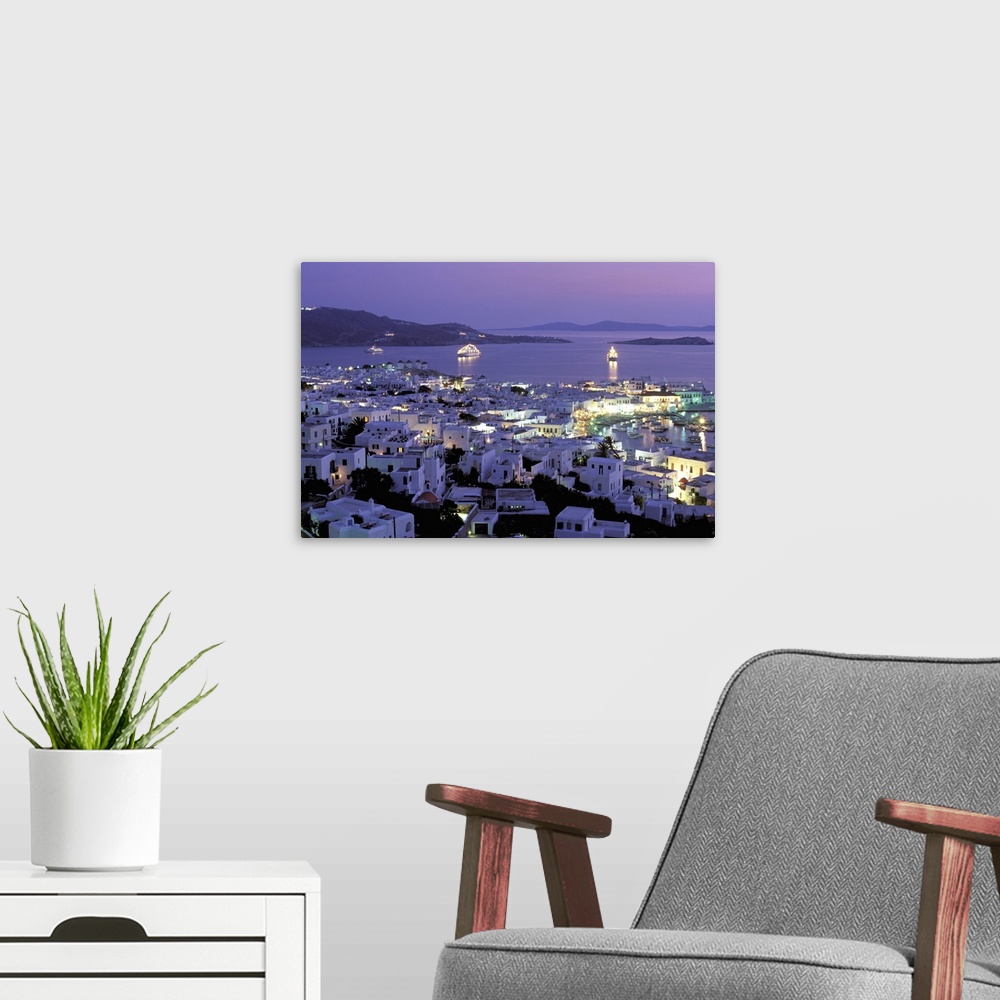 A modern room featuring Europe, Greece, Cyclades Islands, Mykonos. Evening view of Mykonos town from hillside fort