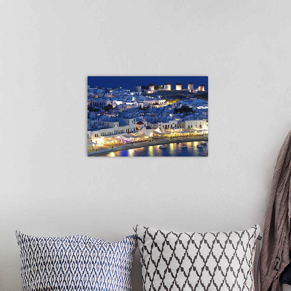 A bohemian room featuring Europe, Greece, Mykonos, Hora. Night view overlooking harbor with illuminated windmills atop hill...