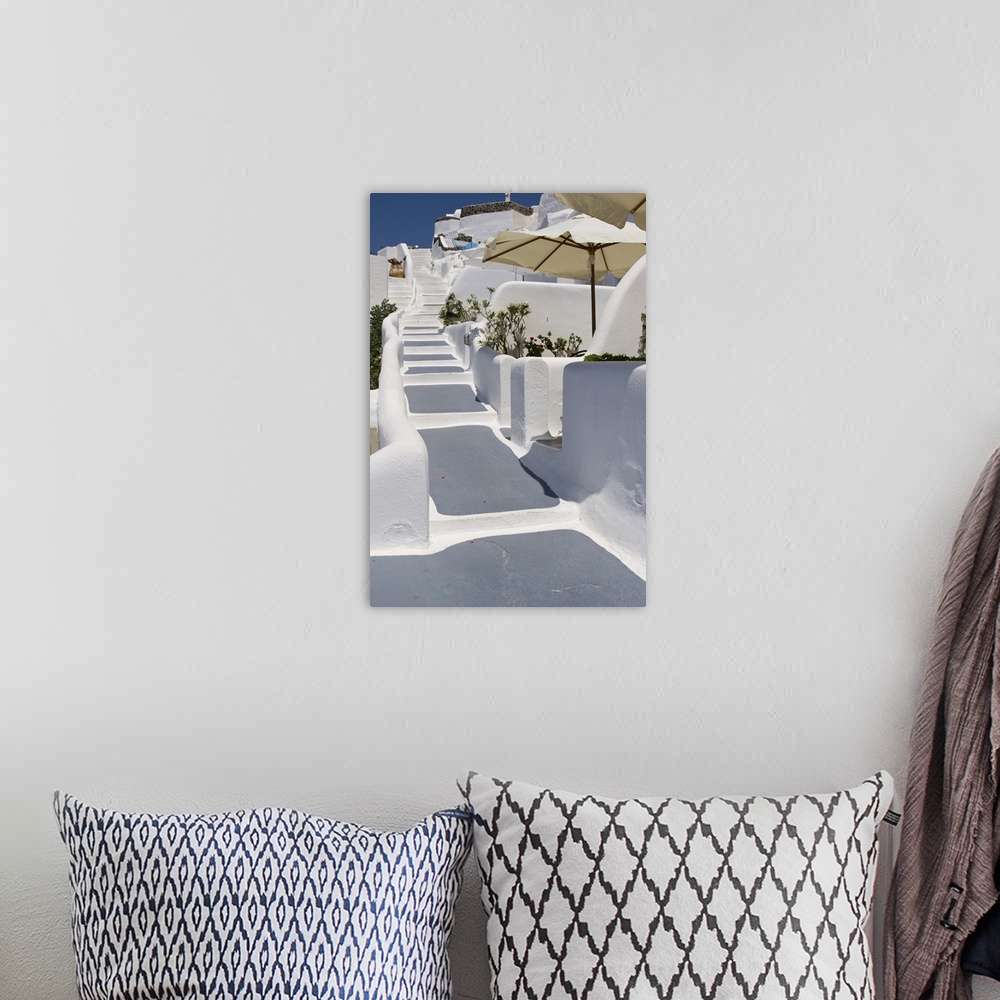 A bohemian room featuring Europe, Greece, Santorini, Thira, Oia. Grey and white painted stairs leading past open patio umbr...