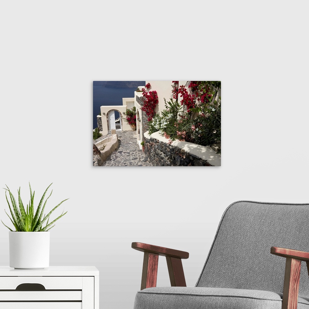 A modern room featuring Europe, Greece, Santorini, Thira, Oia. Pebbled staircase leading past villa door and flower decor...
