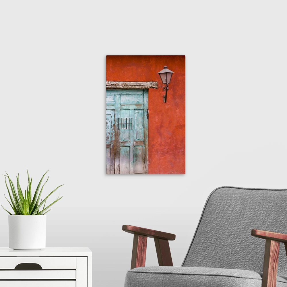 A modern room featuring Central America, Guatemala, Antigua.  Aqua blue door against colorful red wall in Antigua.