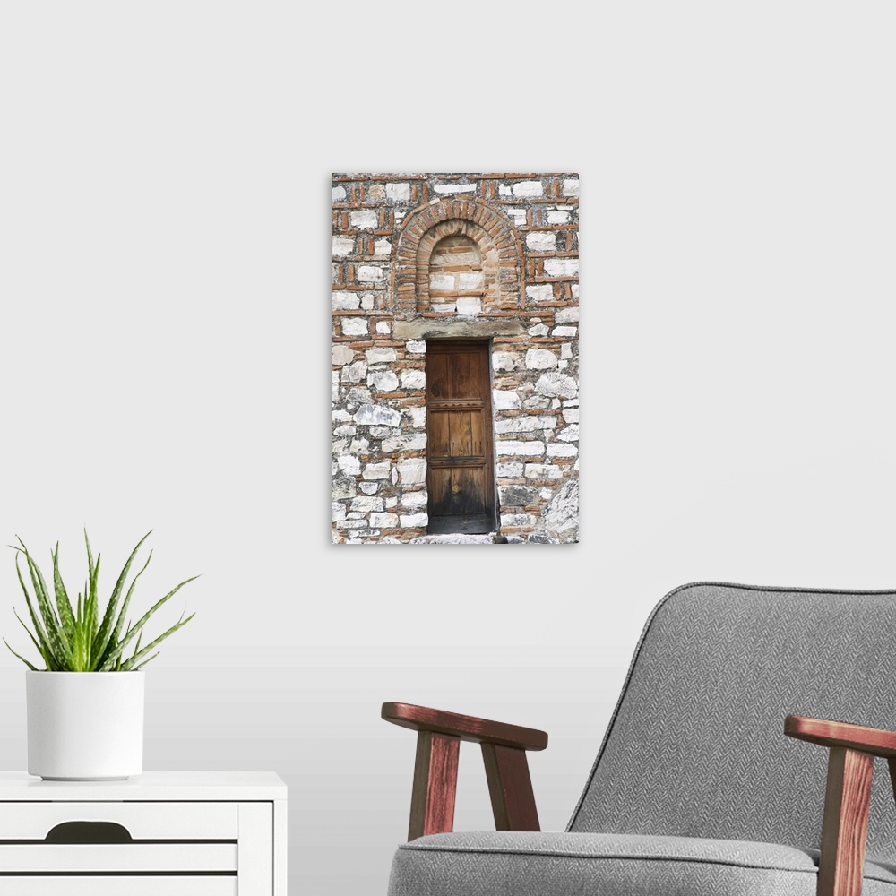 A modern room featuring The Hagia Triada Church. Detail of an old wooden door and arched window. Berat upper citadel old ...
