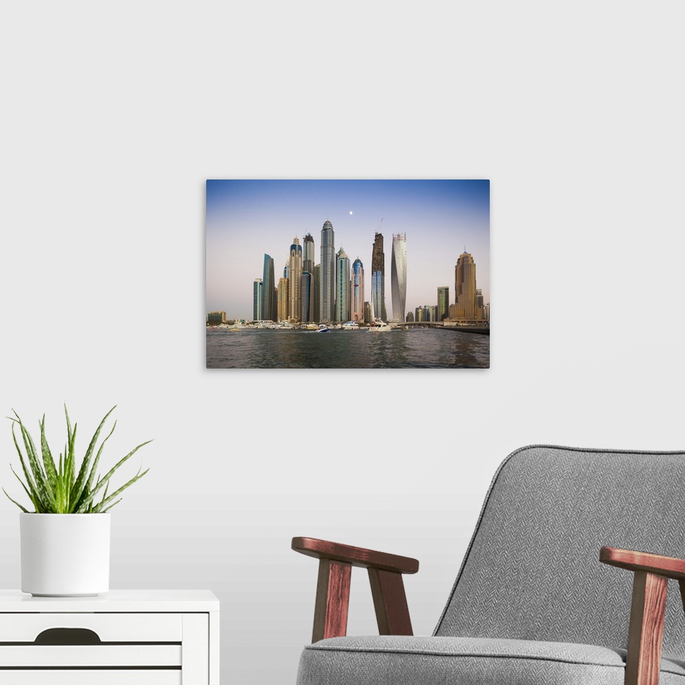 A modern room featuring UAE, Dubai, Dubai Marina, high rise buildings including the twisted Cayan Tower, with moonrise, dusk