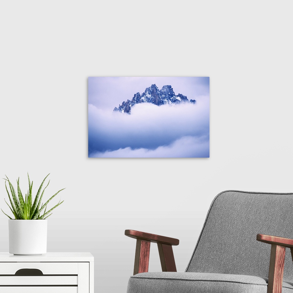 A modern room featuring USA, Idaho, Sawtooth Range. Mountain top peaks through the heavy clouds.