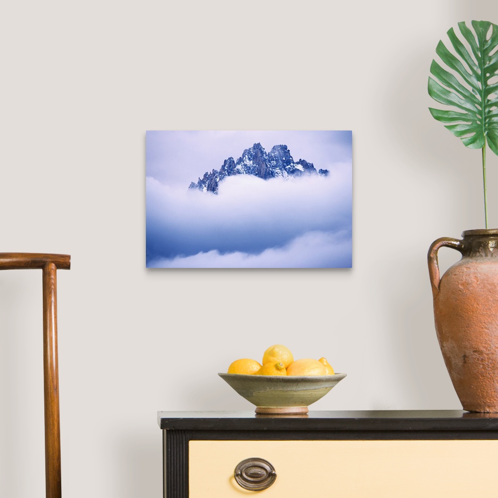 A traditional room featuring USA, Idaho, Sawtooth Range. Mountain top peaks through the heavy clouds.