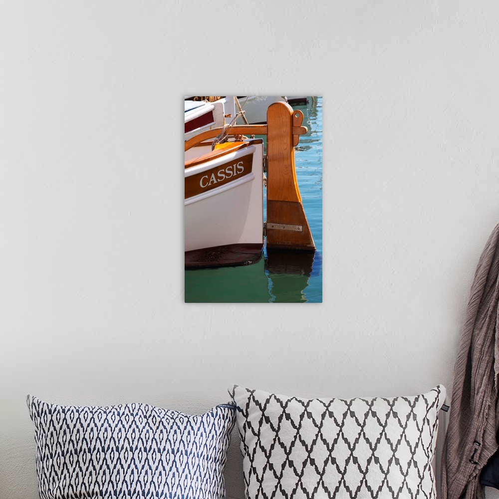 A bohemian room featuring In the harbour in Cassis village.  A traditional style boat with wooden rudder marked with the na...