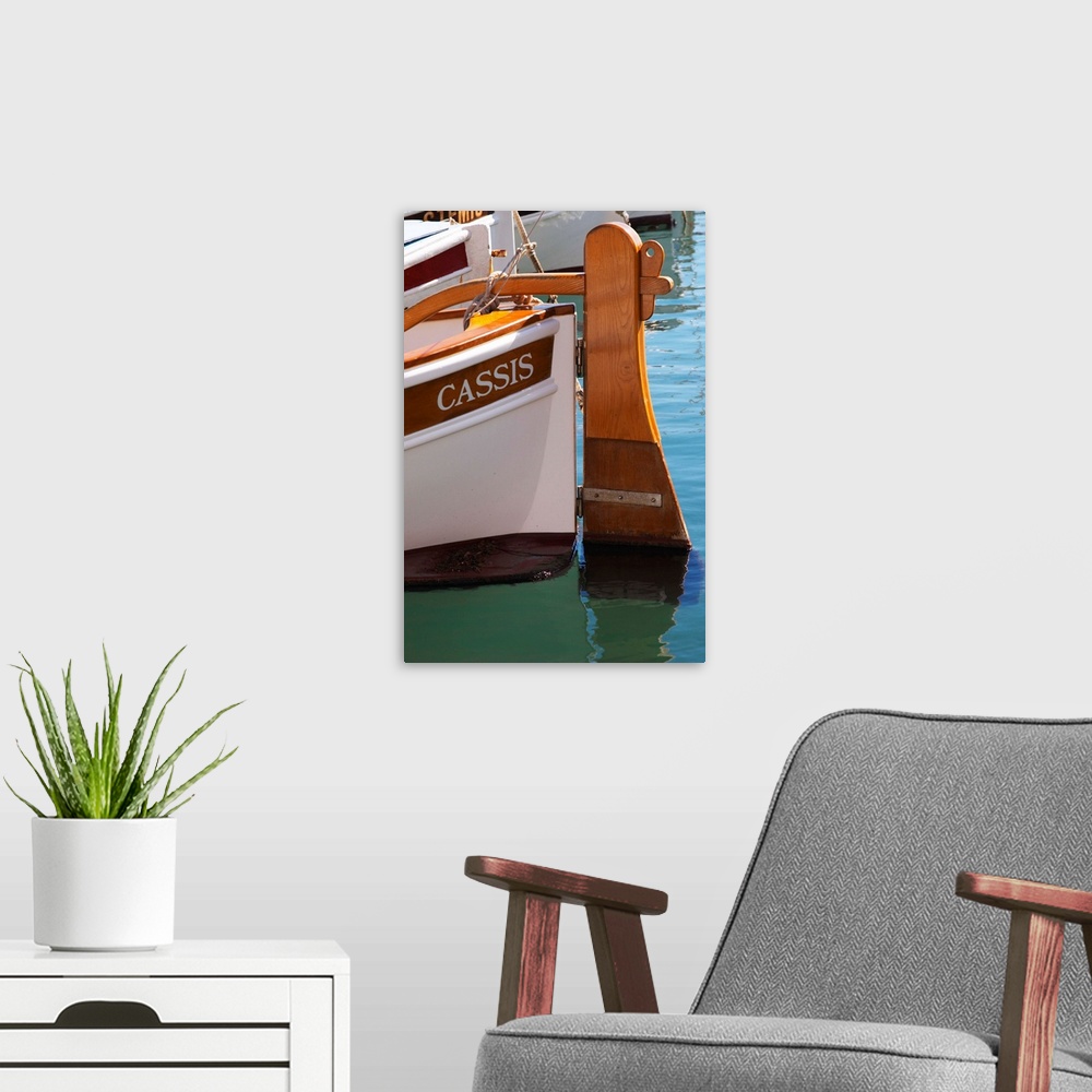 A modern room featuring In the harbour in Cassis village.  A traditional style boat with wooden rudder marked with the na...