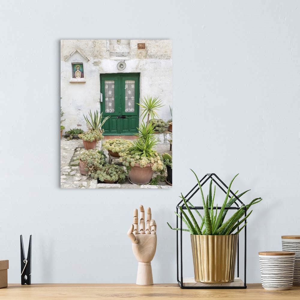 A bohemian room featuring Italy, Basilicata, Matera. Plants adorn the outside walls of the Sassi houses.
