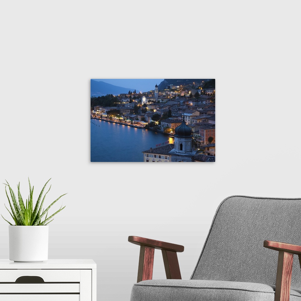 A modern room featuring ITALY, Brescia Province, Limone sul Garda. Aerial town view, dusk.