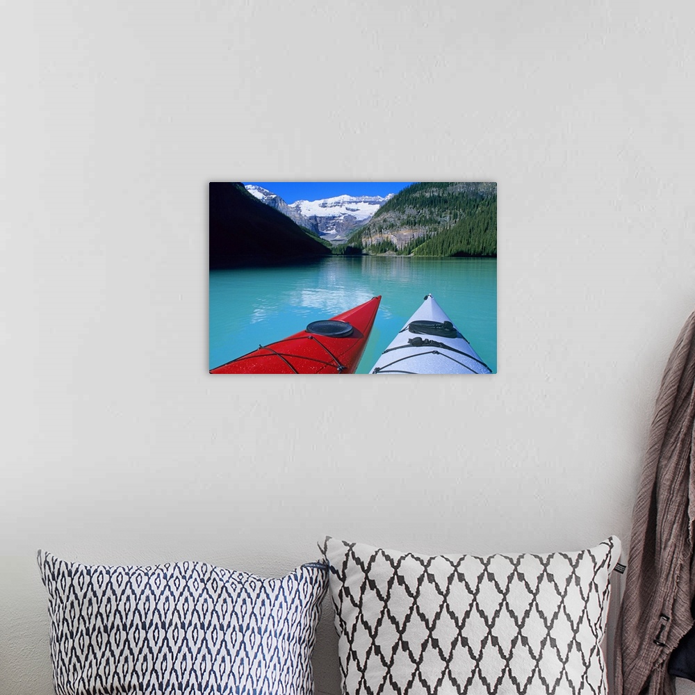 A bohemian room featuring Kayaks on Lake Louise below Mount Victoria in the Canadian Rockies; Banff National Park; Alberta,...