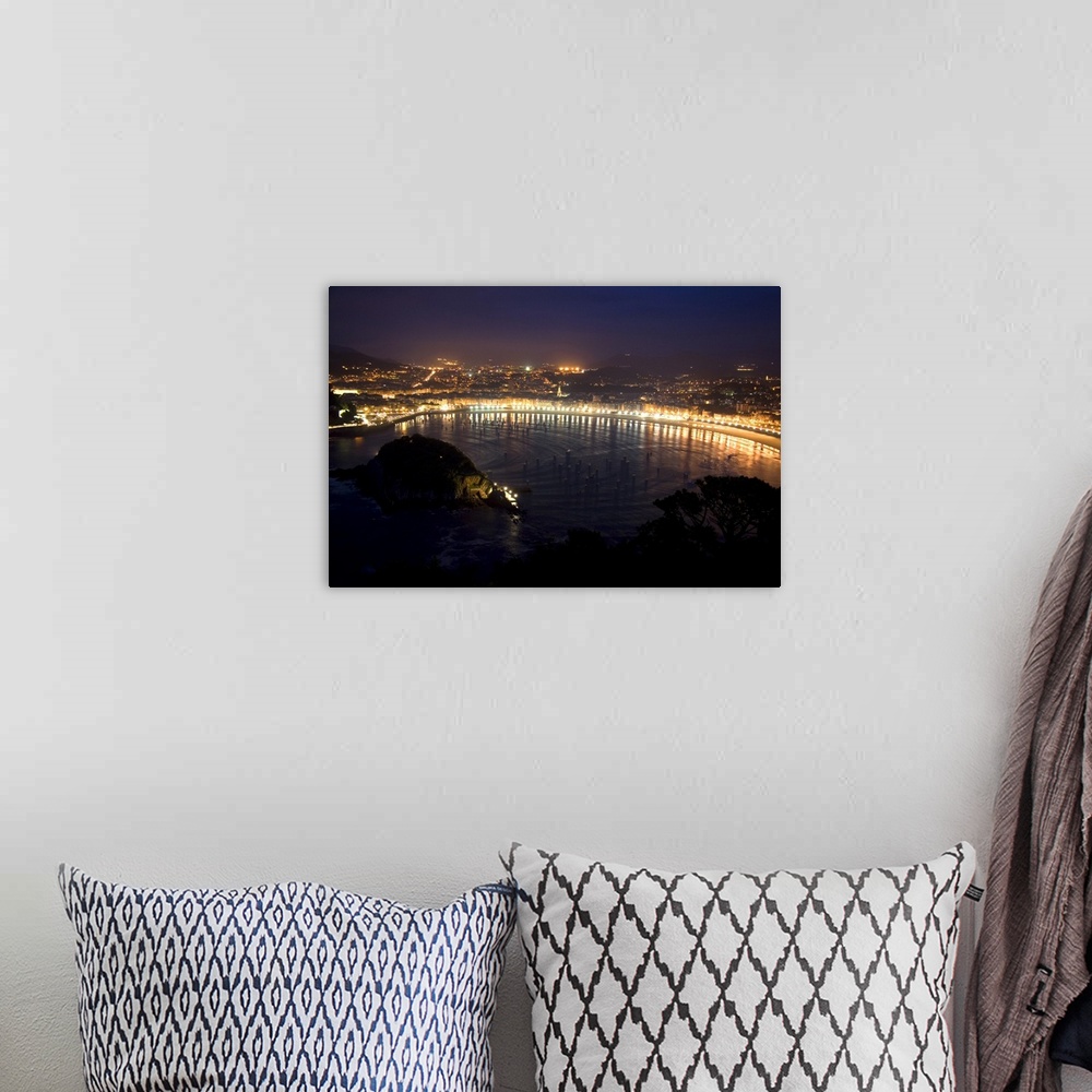 A bohemian room featuring La Concha Bay and the city of Donostia-San Sebastian at night, Guipuzcoa, Basque Country, Norther...