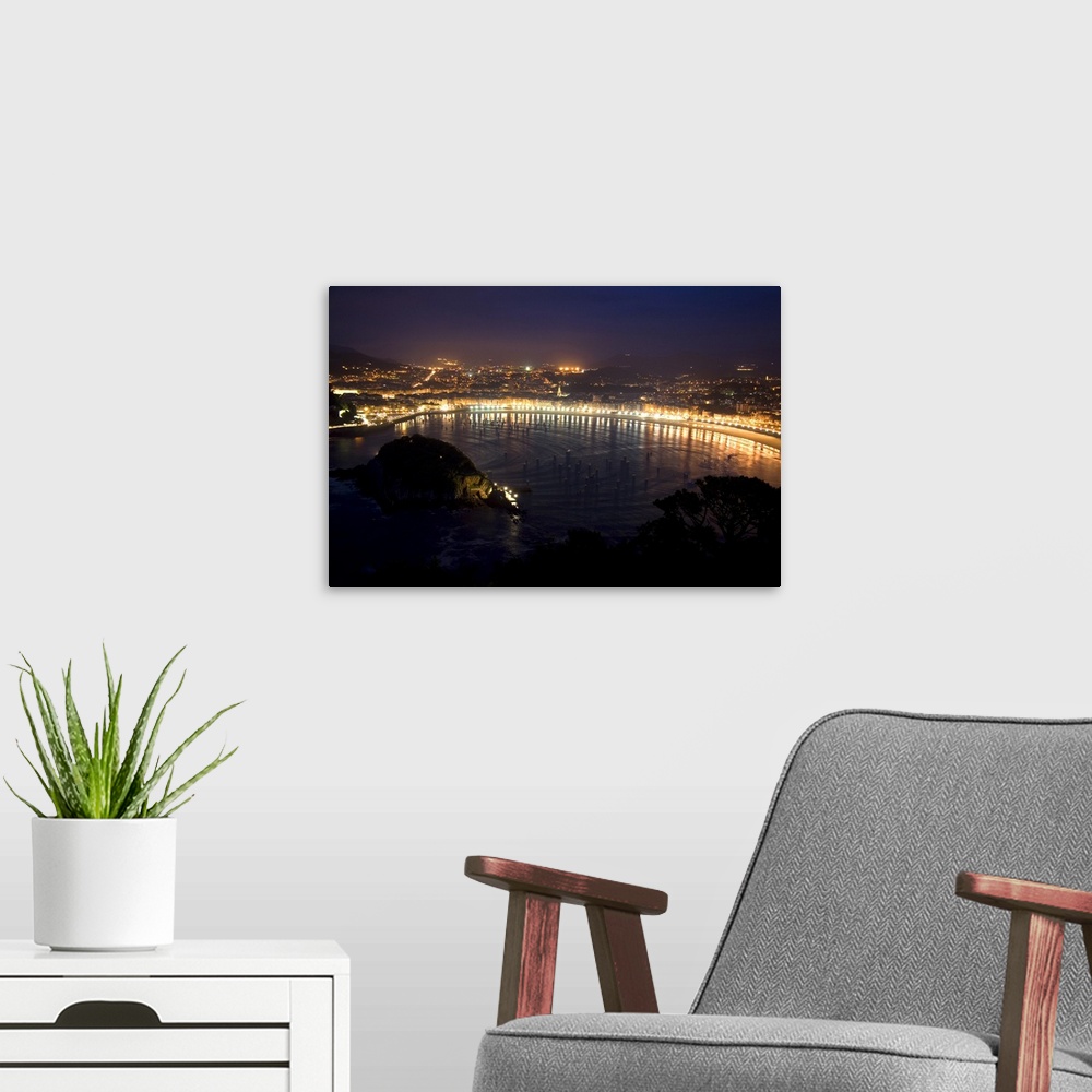 A modern room featuring La Concha Bay and the city of Donostia-San Sebastian at night, Guipuzcoa, Basque Country, Norther...