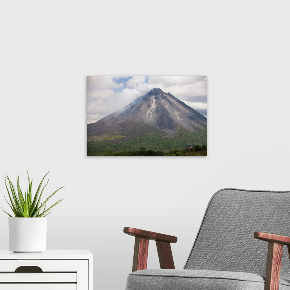 A modern room featuring Lava rocks are thrown from the erupting Arenal volcano to the mountainside and forest below in Ar...
